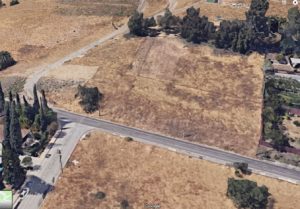 Google Maps screenshot of a hillside road from an aerial view. The road goes through the middle of the image before turning up the hill, while another road turns downs the hill.