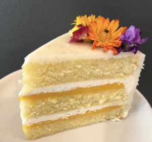 A white and yellow slice of cake, with flowers on the top.